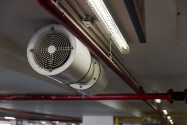Modern bina otoparkının hayranı. Otopark havalandırma sistemi. Fabrikada kapalı alan çalışması için hava akımı. Endüstriyel Fan Isıtıcı ve Soğutucu.