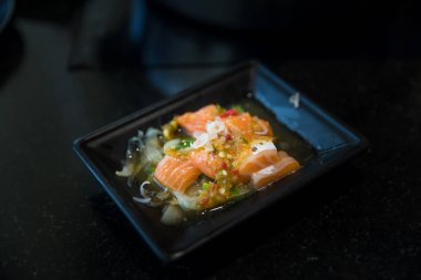 Premium taze çiğ somon ile Japon baharatlı salata sashimi somon. Tofu ve taze sebze ile Asya salatası Karışık dilimlenmiş balık sashimi, ince dilimlenmiş çiğ et somon, ton balığı, Sashimi bir Japon .