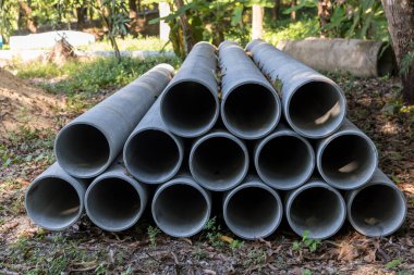 İnşaat alanındaki beton drenaj borusu. İnşaat için yığılmış beton drenaj boruları. Ana yolun yakınındaki inşaat alanında beton drenaj borusu.