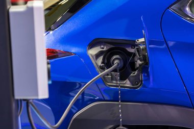 Elektrikli araba şarj istasyonu. Otoparktaki hibrit araba elektrik şarj istasyonu. Elektrikli araba park ve şarj istasyonunda şarj oluyor. Elektrik prizi. Ulaşım EV