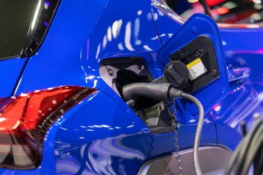 Elektrikli araba şarj istasyonu. Otoparktaki hibrit araba elektrik şarj istasyonu. Elektrikli araba park ve şarj istasyonunda şarj oluyor. Elektrik prizi. Ulaşım EV