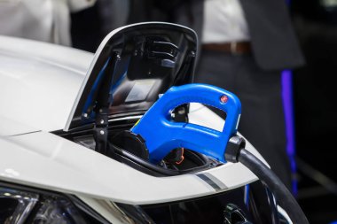 Elektrikli araba şarj istasyonu. Otoparktaki hibrit araba elektrik şarj istasyonu. Elektrikli araba park ve şarj istasyonunda şarj oluyor. Elektrik prizi. Ulaşım EV