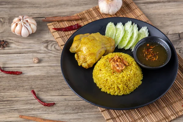 Rice with curried chicken. Delicious spicy chicken biryani in black bowl on wooden background, Indian or Pakistani ramzan food. Homemade Arabian biryani. Traditional spicy Indian food. chicken biryani