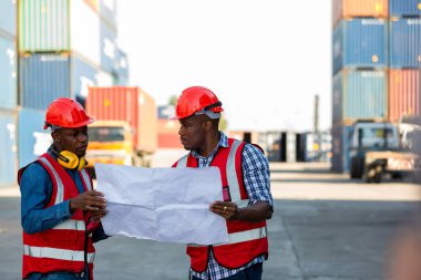 Konteyner kargo alanında çalışan profesyonel ustabaşı konteynırdaki malları kontrol ediyor. İşçiler denetleme ve kontrol için konteynırları açıyorlar..