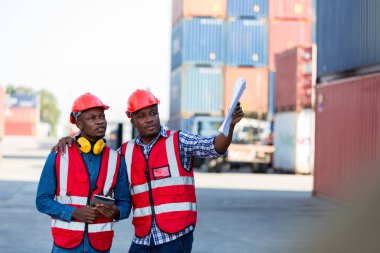 Konteyner kargo alanında çalışan profesyonel ustabaşı konteynırdaki malları kontrol ediyor. İşçiler denetleme ve kontrol için konteynırları açıyorlar..