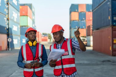 Konteyner kargo alanında çalışan profesyonel ustabaşı konteynırdaki malları kontrol ediyor. İşçiler denetleme ve kontrol için konteynırları açıyorlar..