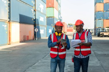 Konteyner kargo alanında çalışan profesyonel ustabaşı konteynırdaki malları kontrol ediyor. İşçiler denetleme ve kontrol için konteynırları açıyorlar..