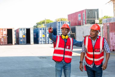 Konteyner kargo alanında çalışan profesyonel ustabaşı konteynırdaki malları kontrol ediyor. İşçiler denetleme ve kontrol için konteynırları açıyorlar..