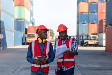 Konteyner kargo alanında çalışan profesyonel ustabaşı konteynırdaki malları kontrol ediyor. İşçiler denetleme ve kontrol için konteynırları açıyorlar..