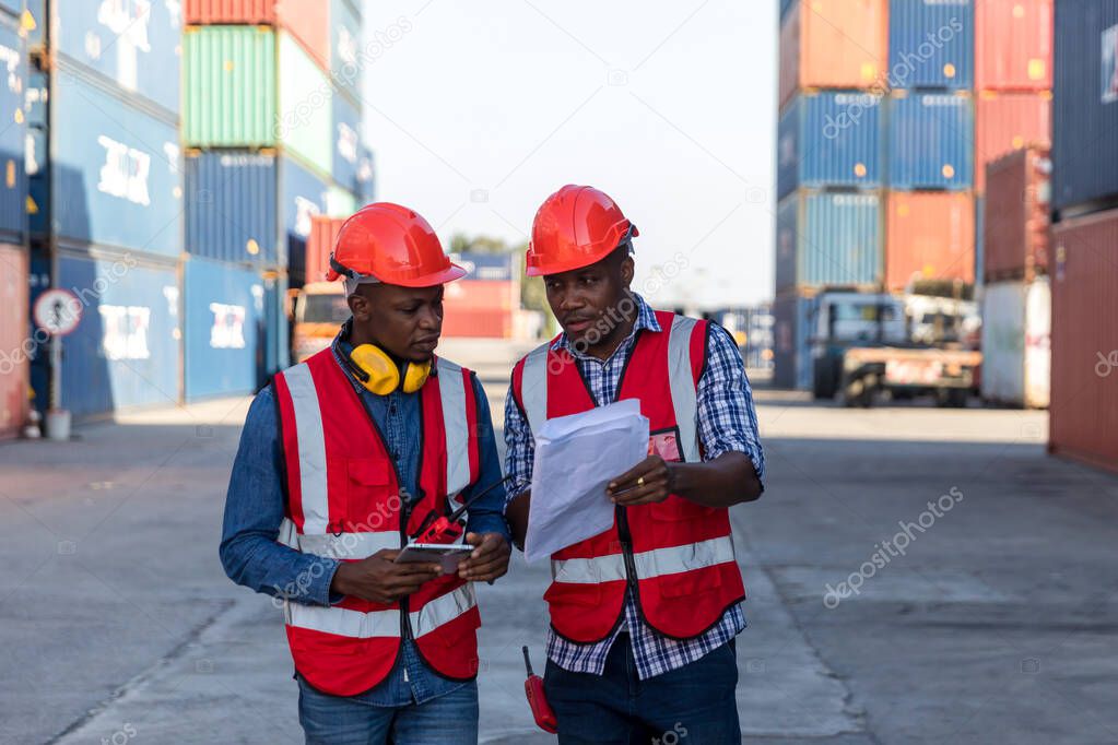 Professional foreman work at Container cargo site check up goods in container. Workers are opening containers for inspection and check.