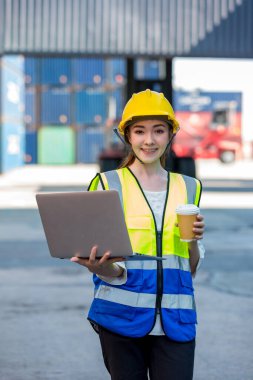 Konteyner kargo alanında çalışan profesyonel ustabaşı konteynırdaki malları kontrol ediyor. İşçiler denetleme ve kontrol için konteynırları açıyorlar..