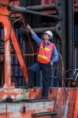 Konteyner kargo alanında çalışan profesyonel ustabaşı konteynırdaki malları kontrol ediyor. İşçiler denetleme ve kontrol için konteynırları açıyorlar..