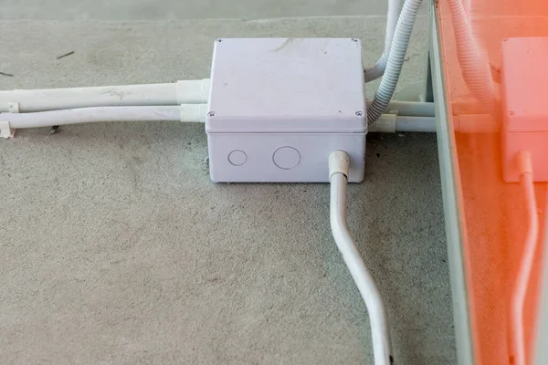 方格地板盒 装有塑料管和电缆 地板上的白色电源插座和电线 在混凝土楼面安装电线 — 图库照片
