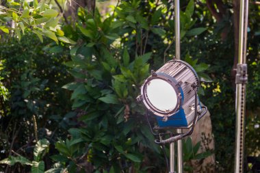 Çekim süreci. Spot ışıkları aydınlatır. Açık havada bir sürü lamba olan bir film seti. Açık havada film ışıkları