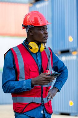 Ustabaşı ya da işçi konteyner kargo şirketinde çalışıyor. Elinde cep telefonu ya da akıllı telefon var. Ustabaşı ya da işçi konteynırları kontrol ediyor. Lojistik ve nakliye.