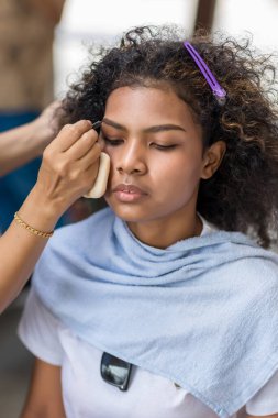 Stilist, kaşlarını fırçalayan siyah kadın kaşlarına makyaj yapıyor. Makyöz stilisti. Kaşlarını fırçayla fırçala. Modeli doğal makyaj yapar.