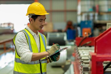 Ustabaşı ya da işçi fabrikada çalışıyor. Kontrol makinesi ya da tesisteki ürünler. Mühendis ya da teknisyen Malzemeleri ya da Tesiste Makine 'yi kontrol ediyor. Ağır sanayi fabrikası konsepti.