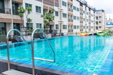 Yüzme havuzuna inmek için merdiven paslanmaz tırabzanlar. Tırabzanlı yüzme havuzu. Yüzme havuzu merdiveni. Yatay çekim. Merdivenler yüzme havuzu. Paslanmaz çelik merdiven.