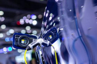 Elektrikli araba şarj istasyonu. Otoparktaki hibrit araba elektrik şarj istasyonu. Elektrikli araba park ve şarj istasyonunda şarj oluyor. Elektrik prizi. Ulaşım EV