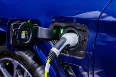 Elektrikli araba şarj istasyonu. Otoparktaki hibrit araba elektrik şarj istasyonu. Elektrikli araba park ve şarj istasyonunda şarj oluyor. Elektrik prizi. Ulaşım EV