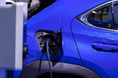 Elektrikli araba şarj istasyonu. Otoparktaki hibrit araba elektrik şarj istasyonu. Elektrikli araba park ve şarj istasyonunda şarj oluyor. Elektrik prizi. Ulaşım EV