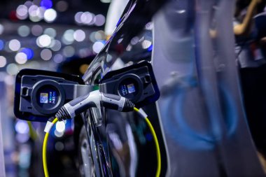 Elektrikli araba şarj istasyonu. Otoparktaki hibrit araba elektrik şarj istasyonu. Elektrikli araba park ve şarj istasyonunda şarj oluyor. Elektrik prizi. Ulaşım EV