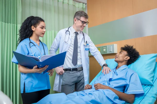 Doctor Visiting man Patient On Ward. Hospitalized man lying in bed while doctor checking his. physician examining male patient in hospital room.