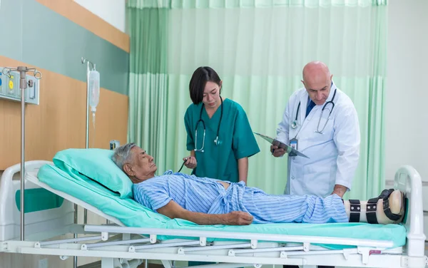 Doctor Visiting man Patient On Ward. Hospitalized man lying in bed while doctor checking his. physician examining male patient in hospital room.