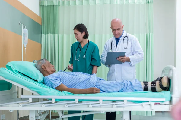 Doctor Visiting man Patient On Ward. Hospitalized man lying in bed while doctor checking his. physician examining male patient in hospital room.