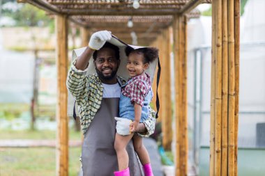 Babası sakallı, kızını kollarına almış yağmurda ona sevgiyle bakıyor. Mutlu bir baba kızını kucaklıyor ve gülüyor..