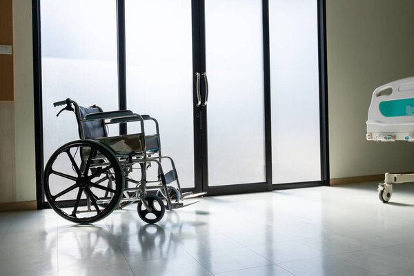 Пустое инвалидное кресло припарковано в палатах в больнице. Пациент в инвалидной коляске в палате больницы. 