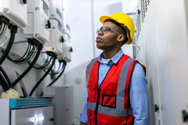 Electrical engineer working in control room. Electrical engineer man checking Power Distribution Cabinet in the control room