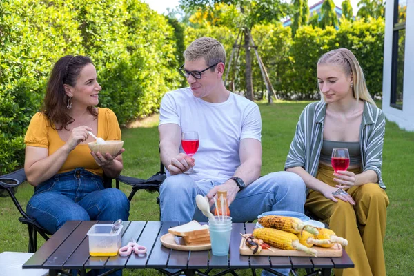 Family enjoy backyard barbecues party. People hanging out at home party. Family having a barbecue party at home. Family Cooking grilled BBQ for Party in backyard. Lifestyle on holiday concept