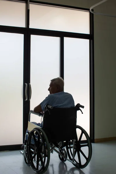 Senior man Patients sitting on wheelchairs. Patients man sitting in modern wheelchair indoors