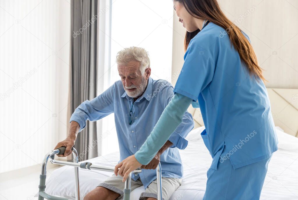 Caregiver nurse take care a Senior patient. Nurse helping senior Man hand holding walker trying to walk