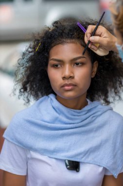 Stilist, kaşlarını fırçalayan siyah kadın kaşlarına makyaj yapıyor. Makyöz stilisti. Kaşlarını fırçayla fırçala. Modeli doğal makyaj yapar.