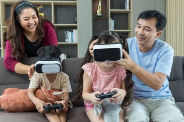 Kızları ve oğulları evde oyun ve öğrenim için sanal gerçeklik gözlüğü kullanıyorlar. Aile aktiviteleri konsepti. VR gözlükleri aile etkinliği