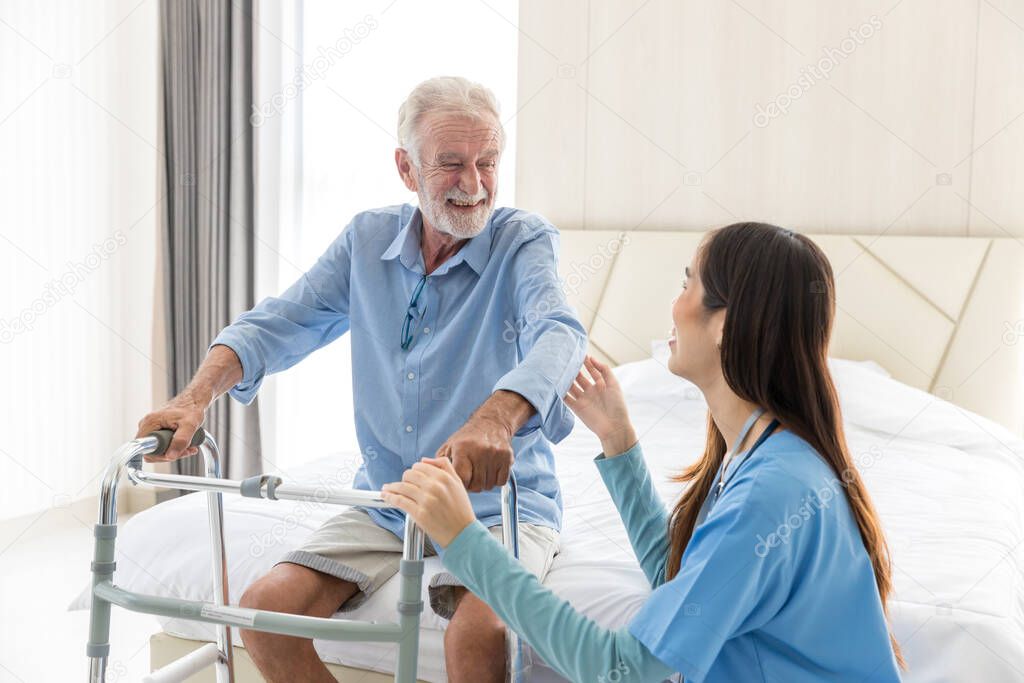 Caregiver nurse take care a Senior patient. Nurse helping senior Man hand holding walker trying to walk