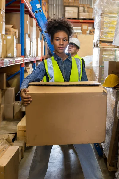african american worker with boxes in warehouse