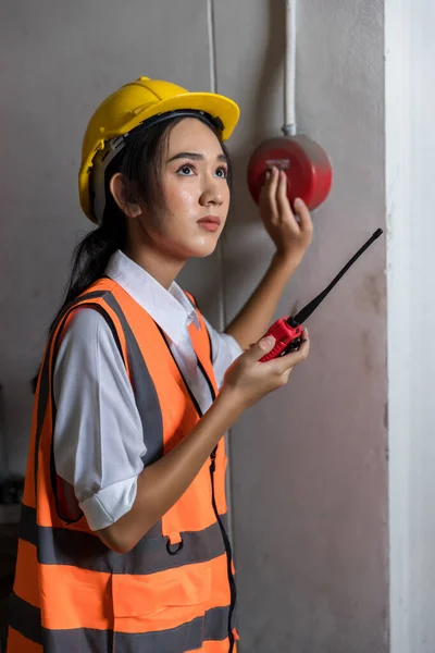 Foreman or worker pushing fire alarm on the wall. A fire! or Emergency case at the factory building. Emergency of Fire alarm or alert or bell warning equipment