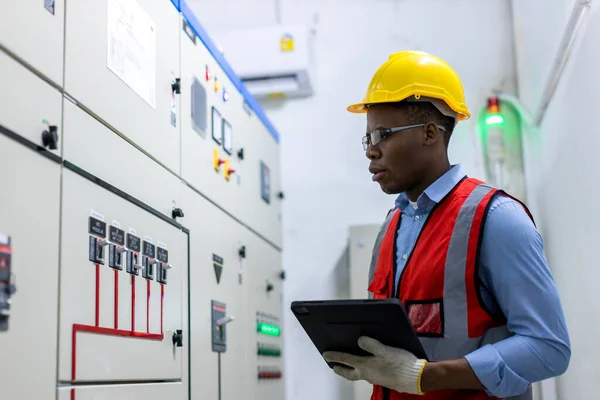 Electrical engineer working in control room. Electrical engineer man checking Power Distribution Cabinet in the control room