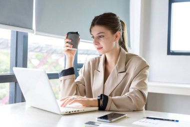 Parlak modern ofiste tablet üzerinde çalışan güzel bir iş kadını