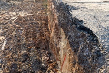 Kırık asfalt yolun kenarları çöktü ve çöktü. Yol çöker. Bölümün altındaki toprak tabakası. Çatlak asfalt yol. İnşaat alanı