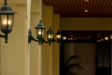 Duvardaki lamba ışığı. Duvarda eski tip demir fener var. Bir köyde bahçe metali elektrik lambası. Duvar lambası dışarıda..