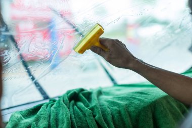 Teknisyen arabanın camını boyuyor. Araba boyama serisi. Araba cam boyama uzmanı araba filmi ön camı yükle.