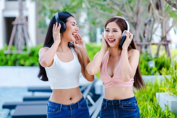 Joyful friends listening to music on line from headphones. Girl dancing and listening music with headphones. beautiful girl happy and dancing