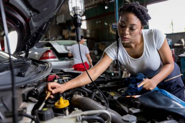 Car mechanic checking  oil quality the engine motor car Transmission and Maintenance Gear. car mechanic in an auto repair shop is checking the engine.