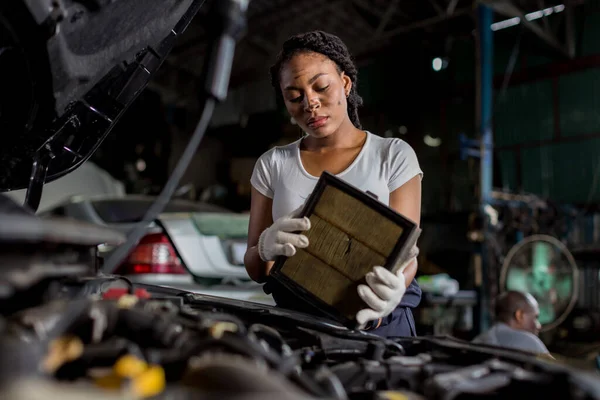 Mechanic is checking and change an air filter. Car mechanic working maintenance checking air filter in repair garage.