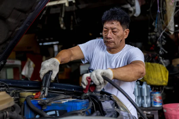 Man charging battery car with electricity cables. Engine engineer is charging car battery because car battery is depleted. concept car maintenance