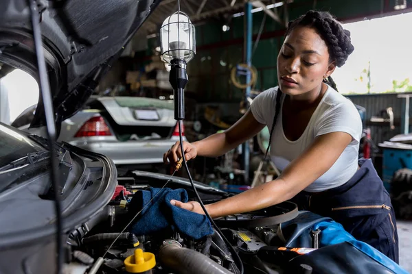 Car mechanic checking  oil quality the engine motor car Transmission and Maintenance Gear. car mechanic in an auto repair shop is checking the engine.